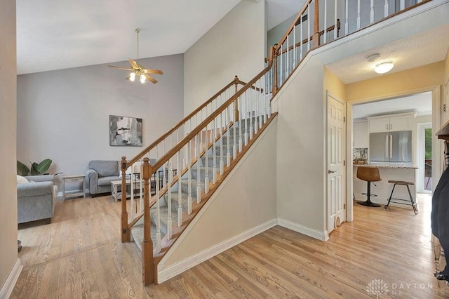 406 Forge Dr, Lebanon, OH 45036 - staircase with a ceiling fan, wood finished floors, high vaulted ceiling, and baseboards