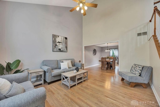 406 Forge Dr, Lebanon, OH 45036 - living area with light wood finished floors, a ceiling fan, baseboards, and a high ceiling