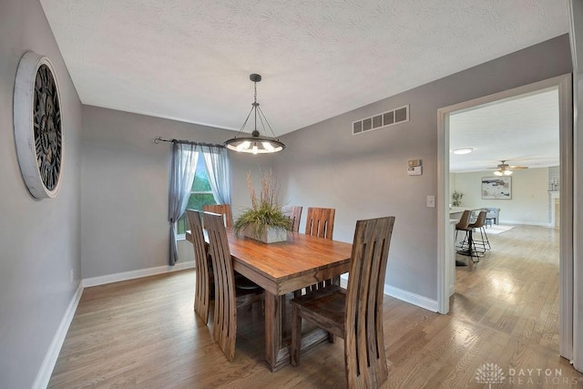 406 Forge Dr, Lebanon, OH 45036 - dining space featuring light wood-style flooring, baseboards, a textured ceiling, and a ceiling fan
