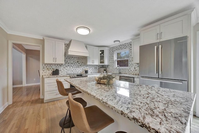 406 Forge Dr, Lebanon, OH 45036 - kitchen featuring custom exhaust hood, a kitchen breakfast bar, ornamental molding, backsplash, and appliances with stainless steel finishes