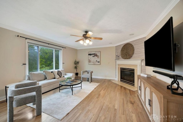 406 Forge Dr, Lebanon, OH 45036 - living room featuring ceiling fan, light wood-style flooring, a fireplace with flush hearth, baseboards, and crown molding