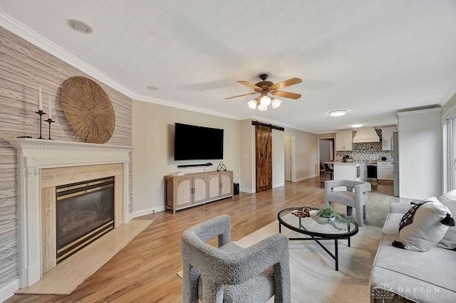406 Forge Dr, Lebanon, OH 45036 - living room with a barn door, ceiling fan, ornamental molding, a fireplace, and baseboards