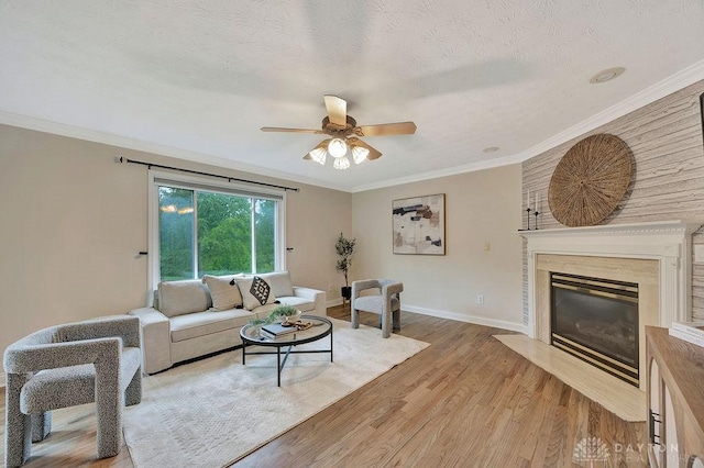 406 Forge Dr, Lebanon, OH 45036 - living area with ceiling fan, light wood finished floors, baseboards, a high end fireplace, and ornamental molding
