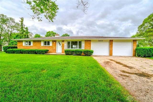 3653 Cloverdale Rd, Medway, OH 45341 - single story home featuring an attached garage, brick siding, a front yard, concrete driveway, and a chimney