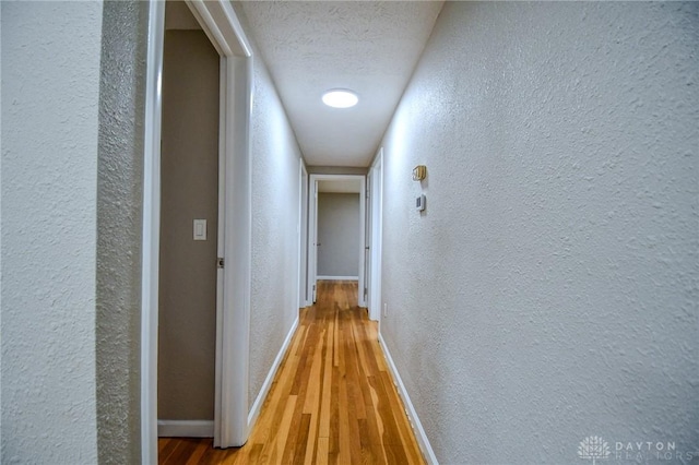 3653 Cloverdale Rd, Medway, OH 45341 - hall featuring a textured wall, baseboards, wood finished floors, and a textured ceiling