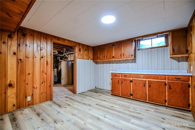 3653 Cloverdale Rd, Medway, OH 45341 - kitchen with gas water heater, light wood finished floors, brown cabinetry, light countertops, and wood walls
