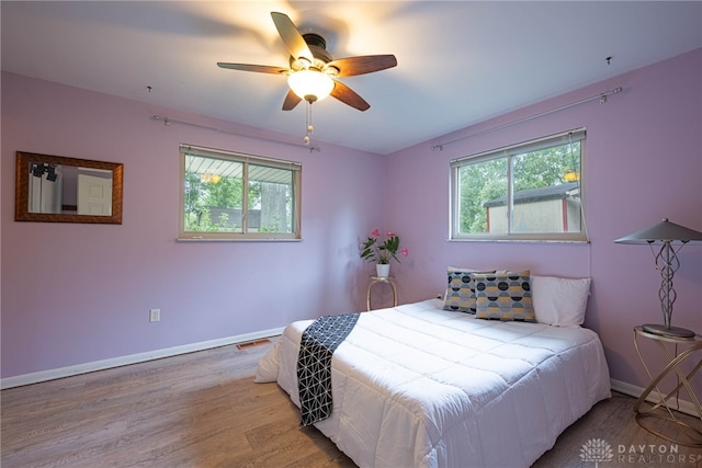 2444 Tennyson Dr, Bellbrook, OH 45305 - bedroom with multiple windows, baseboards, wood finished floors, and ceiling fan