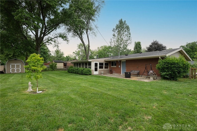 2444 Tennyson Dr, Bellbrook, OH 45305 - back of property with a patio, a lawn, and brick siding