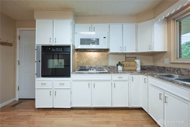 2444 Tennyson Dr, Bellbrook, OH 45305 - kitchen featuring black oven, white microwave, electric cooktop, light wood-style flooring, and white cabinetry