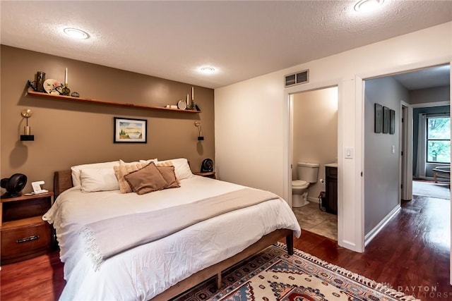 9492 Colegate Way, West Chester, OH 45011 - bedroom featuring wood finished floors, a textured ceiling, connected bathroom, and baseboards