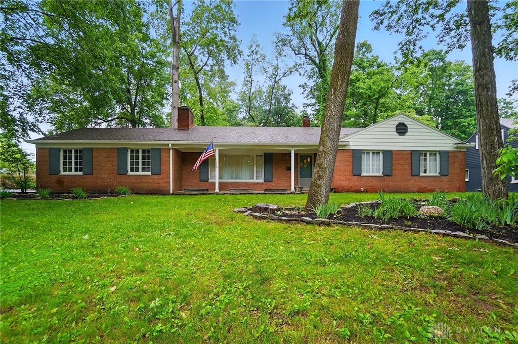 1331 Tall Timber Trl, Dayton, OH 45409 - single story home with a chimney, a front lawn, brick siding, and covered porch