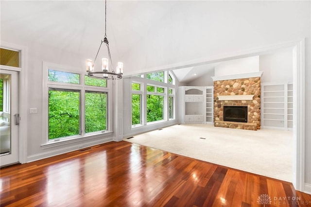 7721 Country Brook Ct, Springboro, OH 45066 - unfurnished living room featuring a chandelier, wood finished floors, a stone fireplace, and high vaulted ceiling