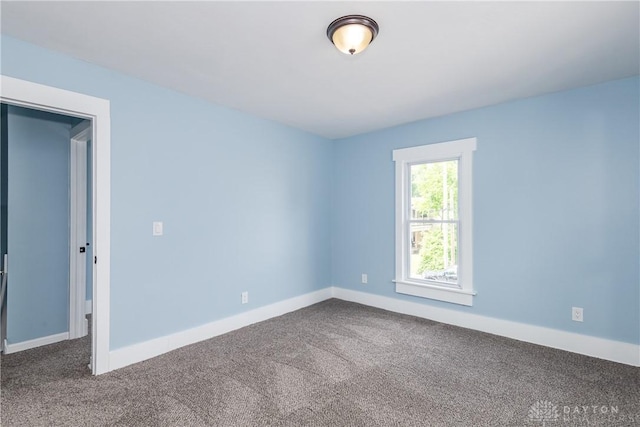 1015 Maiden Ln, Springfield, OH 45504 - empty room featuring dark colored carpet and baseboards
