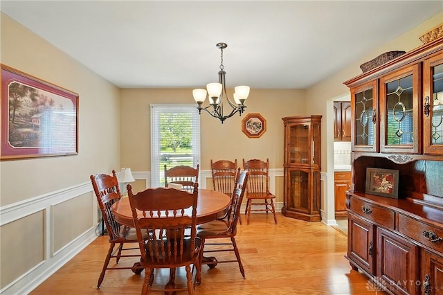 601 Tara Oaks Dr, Middletown, OH 45042 - dining room with a chandelier, light wood finished floors, a wainscoted wall, and a decorative wall