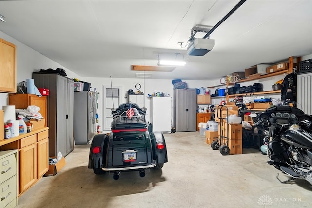 601 Tara Oaks Dr, Middletown, OH 45042 - garage featuring stainless steel refrigerator with ice dispenser, a garage door opener, and freestanding refrigerator