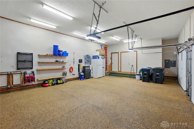 1129 Green Tree Rd, Centerville, OH 45429 - garage featuring freestanding refrigerator, electric panel, and a garage door opener
