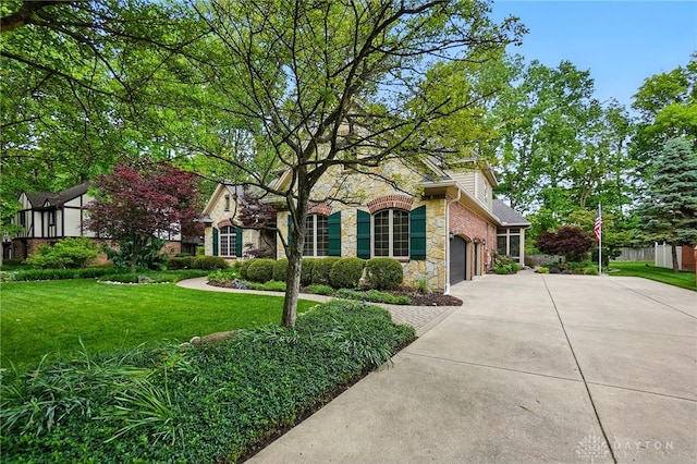1129 Green Tree Rd, Centerville, OH 45429 - view of front of home featuring stone siding, driveway, a front yard, and a garage