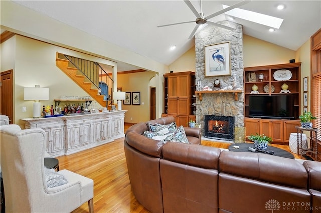 1129 Green Tree Rd, Centerville, OH 45429 - living area featuring a ceiling fan, light wood finished floors, stairs, a stone fireplace, and bar area