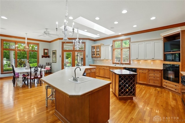 1129 Green Tree Rd, Centerville, OH 45429 - kitchen featuring black appliances, a large island with sink, a sink, ornamental molding, and recessed lighting