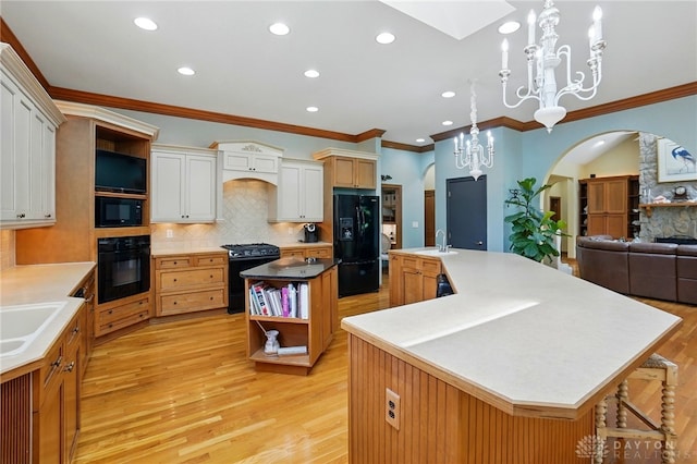 1129 Green Tree Rd, Centerville, OH 45429 - kitchen with black appliances, arched walkways, a spacious island, open shelves, and a sink