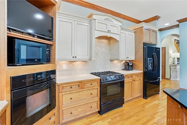 1129 Green Tree Rd, Centerville, OH 45429 - kitchen featuring black appliances, arched walkways, decorative backsplash, crown molding, and light wood-style flooring
