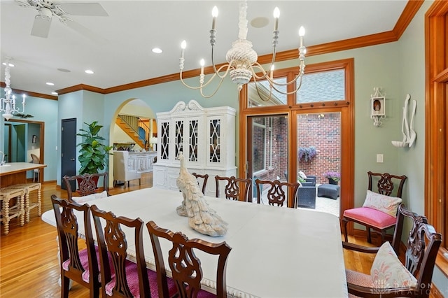 1129 Green Tree Rd, Centerville, OH 45429 - dining area featuring ornamental molding, arched walkways, light wood-type flooring, a chandelier, and a ceiling fan
