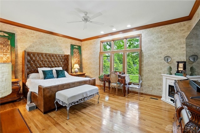 1129 Green Tree Rd, Centerville, OH 45429 - bedroom with crown molding, wood finished floors, a glass covered fireplace, and wallpapered walls