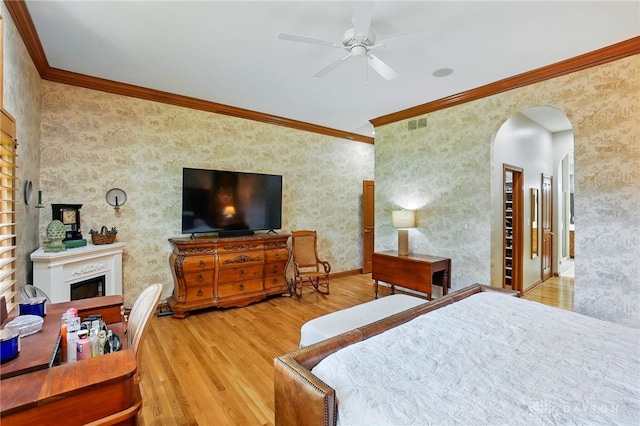 1129 Green Tree Rd, Centerville, OH 45429 - bedroom with arched walkways, ornamental molding, wood finished floors, a fireplace, and wallpapered walls