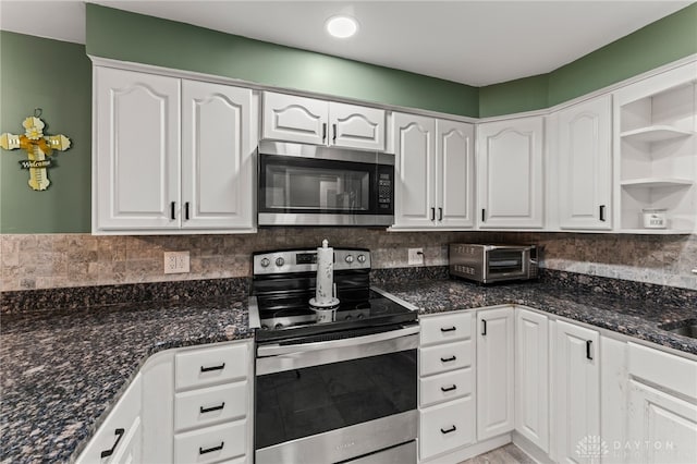 1012 W Sparrow Rd, Springfield, OH 45502 - kitchen featuring appliances with stainless steel finishes, white cabinets, dark stone countertops, and decorative backsplash