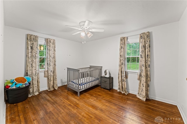 1012 W Sparrow Rd, Springfield, OH 45502 - bedroom featuring hardwood / wood-style flooring, a crib, baseboards, and a ceiling fan