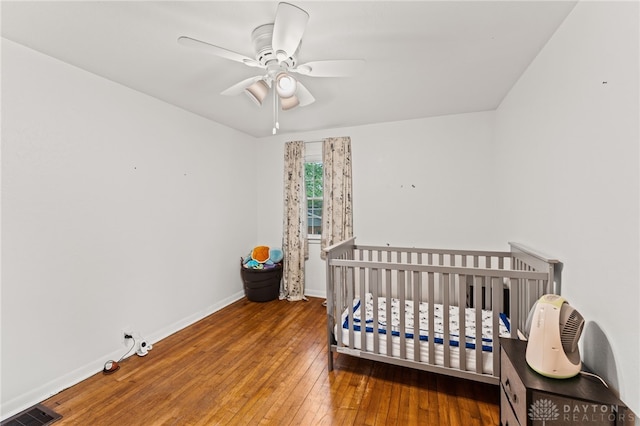 1012 W Sparrow Rd, Springfield, OH 45502 - bedroom with hardwood / wood-style flooring, baseboards, a ceiling fan, and a nursery area