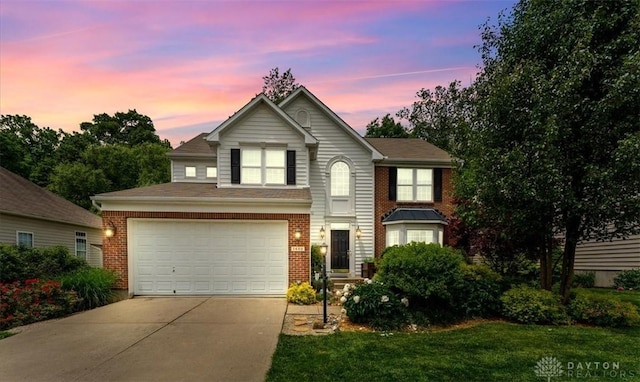 1422 Shawnee Run Dr, Maineville, OH 45039 - traditional-style house featuring concrete driveway, brick siding, a garage, and a lawn