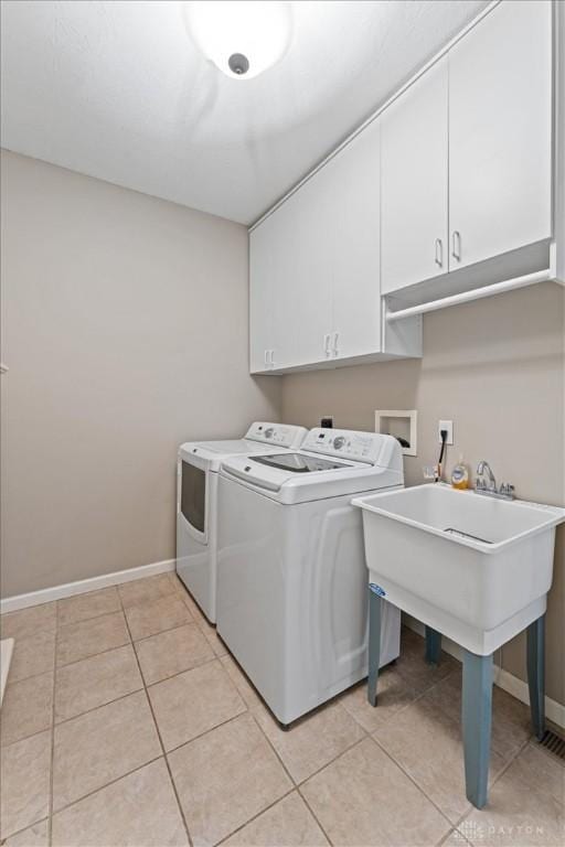 1422 Shawnee Run Dr, Maineville, OH 45039 - laundry room featuring cabinet space, washing machine and clothes dryer, light tile patterned flooring, and baseboards