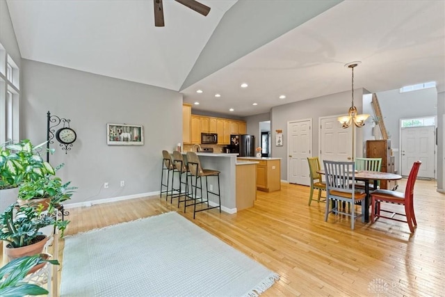 1422 Shawnee Run Dr, Maineville, OH 45039 - kitchen featuring black appliances, lofted ceiling, a peninsula, a ceiling fan, and light wood finished floors
