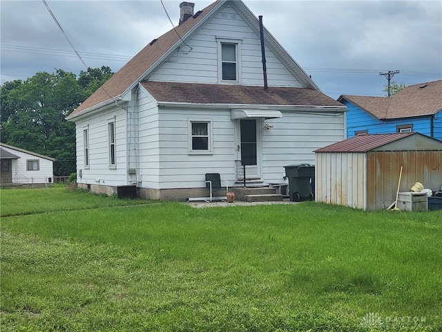 211 Nordale Ave, Dayton, OH 45420 - rear view of house featuring a shingled roof, entry steps, a lawn, and a chimney