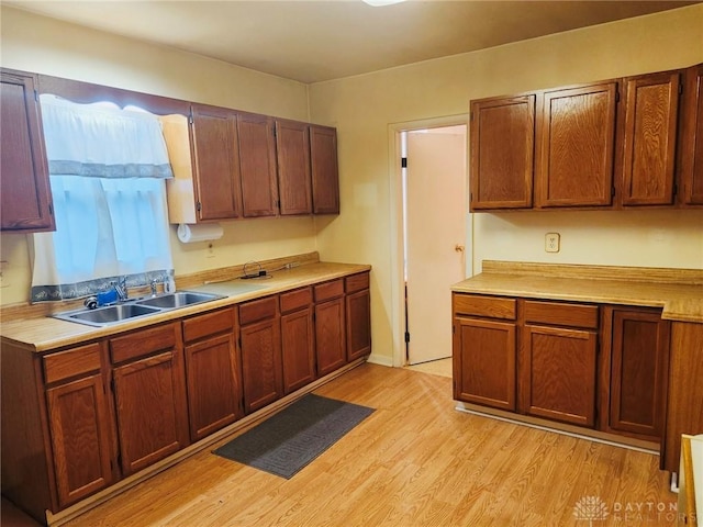 211 Nordale Ave, Dayton, OH 45420 - kitchen with a sink, light wood-style floors, light countertops, and brown cabinetry