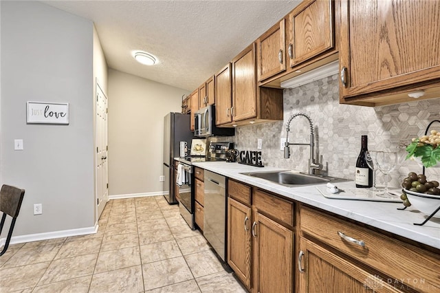 1690 Piper Ln Unit 206, Washington Twp, OH 45440 - kitchen with a sink, appliances with stainless steel finishes, brown cabinets, decorative backsplash, and light countertops