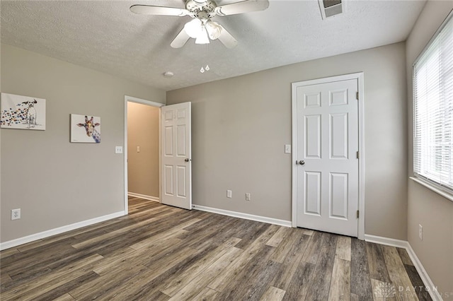 1690 Piper Ln Unit 206, Washington Twp, OH 45440 - unfurnished bedroom featuring wood finished floors, a textured ceiling, multiple windows, baseboards, and a ceiling fan
