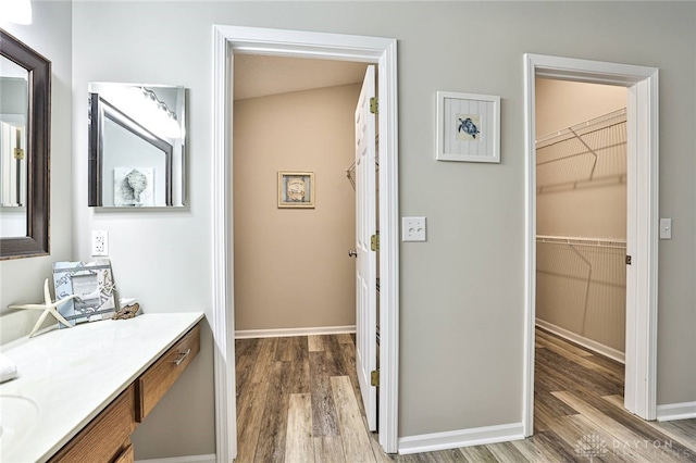 1690 Piper Ln Unit 206, Washington Twp, OH 45440 - bathroom with wood finished floors, vanity, a spacious closet, and baseboards