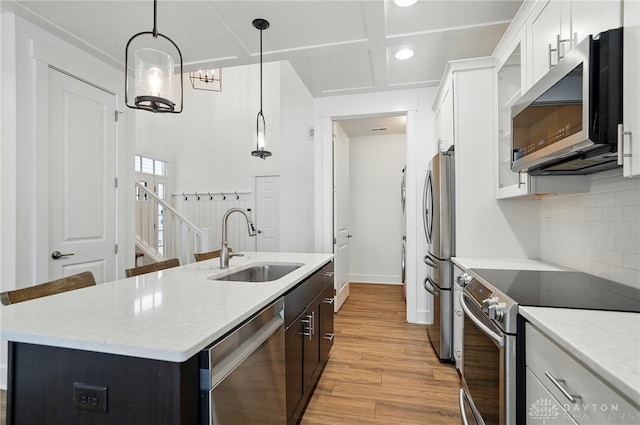 641 Angler Ct, Beavercreek, OH 45430 - kitchen with stainless steel appliances, a sink, light wood-type flooring, backsplash, and white cabinetry