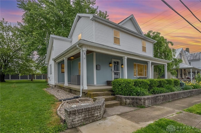107 S High St, Arcanum, OH 45304 - view of front of house featuring covered porch and a front lawn