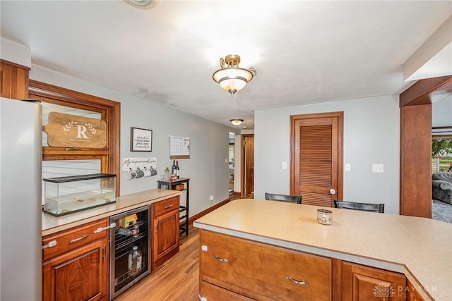 107 S High St, Arcanum, OH 45304 - kitchen featuring wine cooler, light wood-style floors, light countertops, and brown cabinets