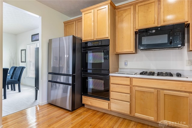 1233 Terrington Way, Miamisburg, OH 45342 - kitchen featuring black appliances, light wood-style flooring, and light countertops