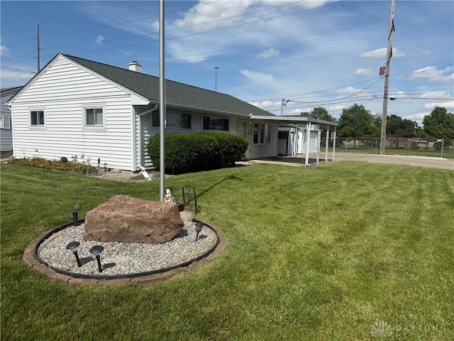 409 Skyview Dr, Vandalia, OH 45377 - rear view of property with a yard, a shingled roof, an attached carport, and driveway