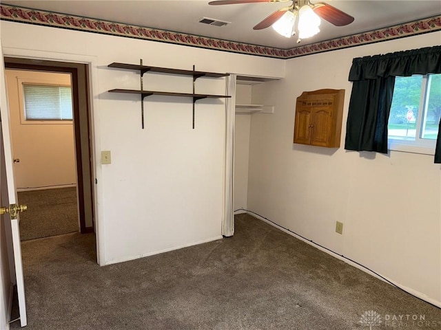 409 Skyview Dr, Vandalia, OH 45377 - unfurnished bedroom featuring dark colored carpet, a closet, and a ceiling fan