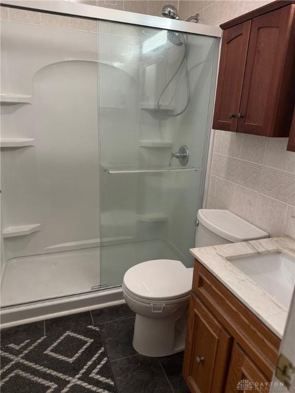 409 Skyview Dr, Vandalia, OH 45377 - bathroom featuring a shower stall, vanity, toilet, tile patterned flooring, and backsplash