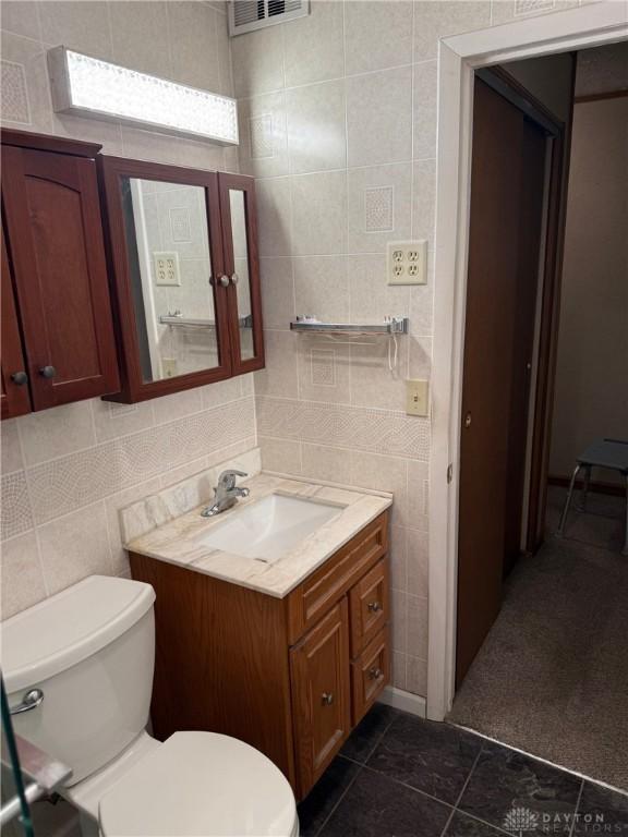 409 Skyview Dr, Vandalia, OH 45377 - half bathroom with tile walls, vanity, and toilet