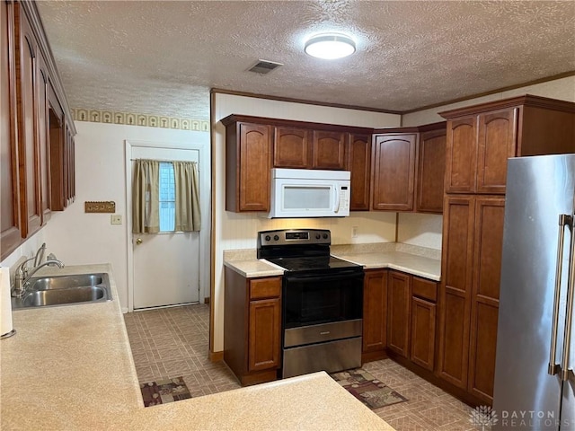 409 Skyview Dr, Vandalia, OH 45377 - kitchen with stainless steel appliances, a sink, a textured ceiling, light countertops, and light flooring