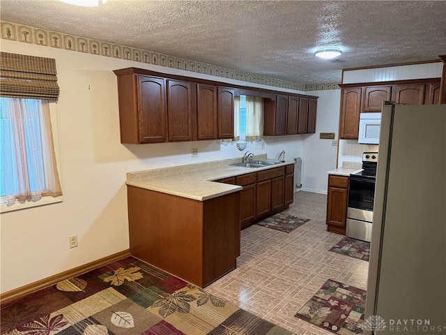 409 Skyview Dr, Vandalia, OH 45377 - kitchen with white appliances, a sink, a textured ceiling, light countertops, and baseboards