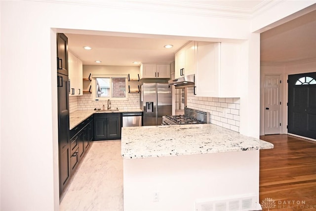 1525 Forrer Blvd, Kettering, OH 45420 - kitchen featuring appliances with stainless steel finishes, under cabinet range hood, crown molding, a peninsula, and light wood finished floors